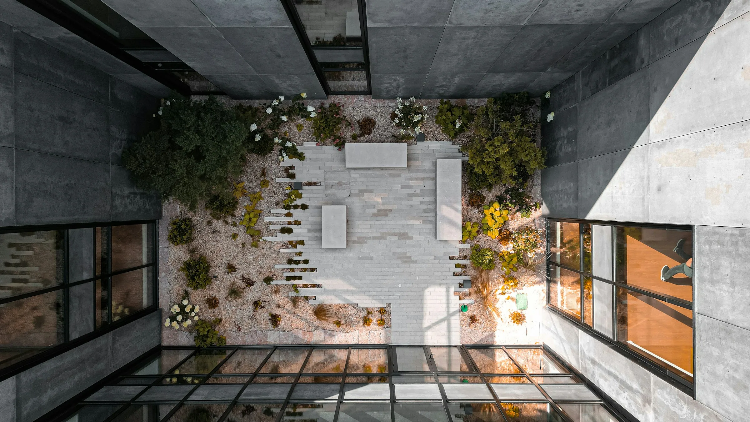 Concrete courtyard seen from above, its floor divided by long geometric shadows
